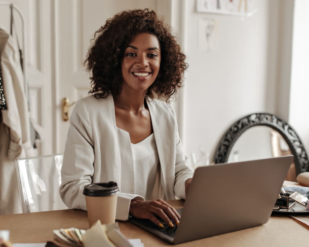 Young business woman sitting in front of a laptop at a desk.